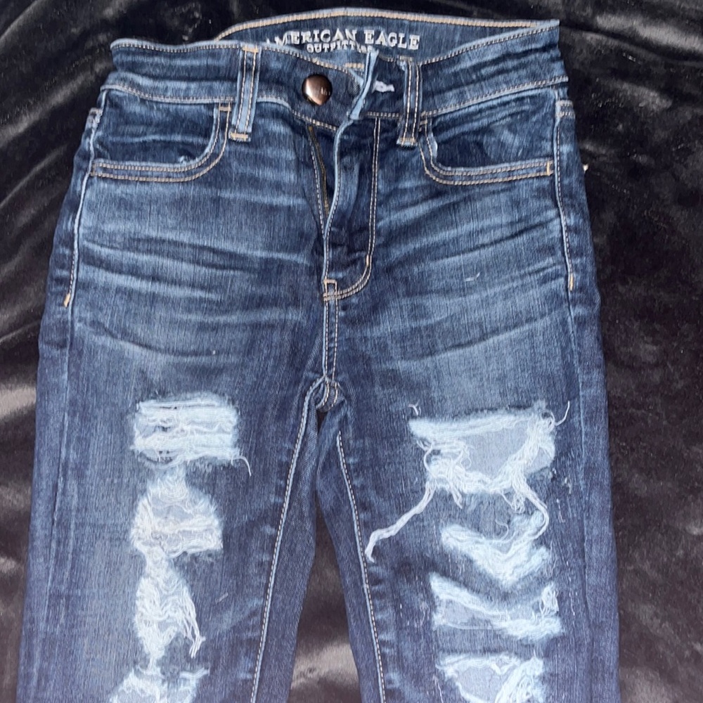 dark grey american eagle jeans with rips on both legs